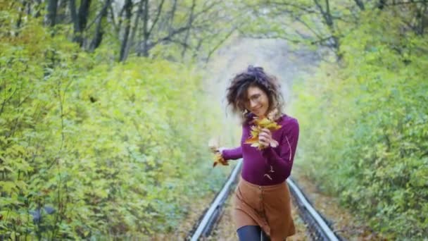 Happy young female tourist spinning in the tunnel of love with autumn leaves, breathing fresh air, hair fluttering in the wind, people freedom concept. happiness. — стоковое видео