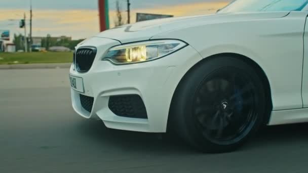 Krivoy Rog, Ukraine - 05.07.2022: Rolling shot of a BMW 3 series, German car, luxury sports sedan driving on a highway at sunset, close-up view — Stockvideo