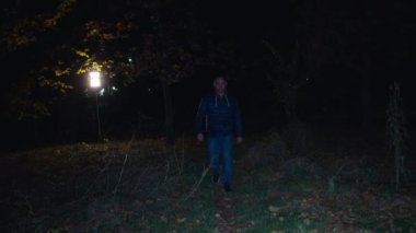 Sinematik çekim, bir adam karanlık bir ormanda yürür, ürpertici bir zombi kadın karanlıktan kaçar ve saldırır. Korkunç. Cadılar Bayramı. Gerçek şeytan.