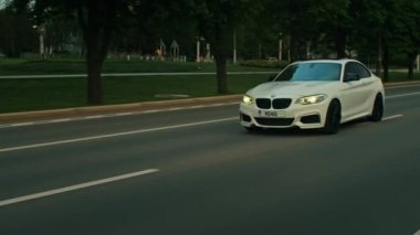 BMW 3 serisi, Alman arabası, gün batımında otoyolda giden lüks spor sedan, yakın çekim.