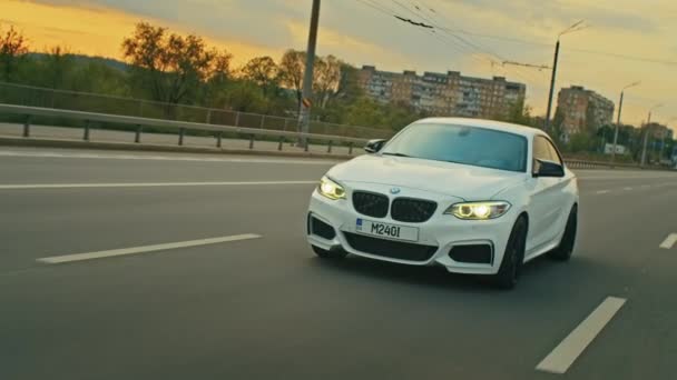Rolling shot of a BMW 3 series, German car, luxury sports sedan driving on a highway at sunset, close-up view