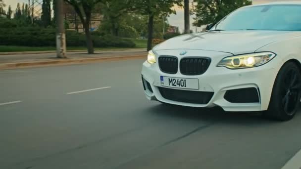 Krivoy Rog, Ukraine - 05.07.2022: Rolling shot of a BMW 3 series, German car, luxury sports sedan driving on a highway at sunset, close-up view — ストック動画