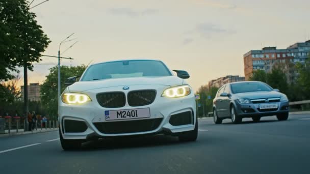 Krivoy Rog, Ukraine - 05.07.2022: Rolling shot of a BMW 3 series, German car, luxury sports sedan driving on a highway at sunset, close-up view — Vídeos de Stock