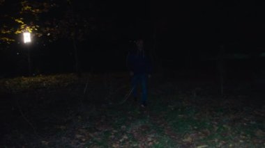 Sinematik çekim, bir adam karanlık bir ormanda yürür, ürpertici bir zombi kadın karanlıktan kaçar ve saldırır. Korkunç. Cadılar Bayramı. Gerçek şeytan..