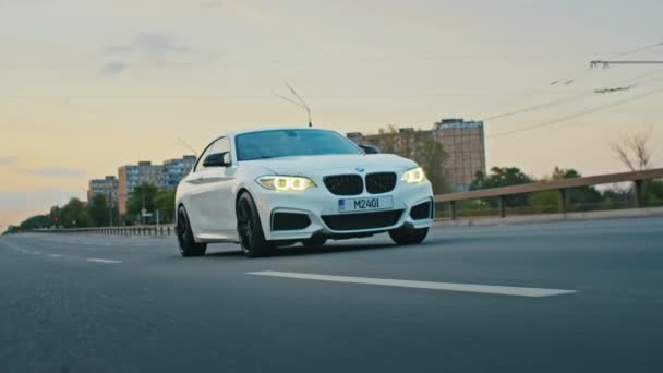 Krivoy Rog, Ukraine - 05.07.2022: Rolling shot of a BMW 3 series, German car, luxury sports sedan driving on a highway at sunset, close-up view — Vídeo de Stock