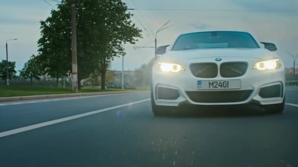 Krivoy Rog, Ucraina - 05.07.2022: Rotolamento di una BMW 3 serie, auto tedesca, berlina sportiva di lusso alla guida su un'autostrada al tramonto, vista da vicino — Video Stock