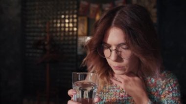 a sad girl is not feeling well, she drinks water to make herself feel better