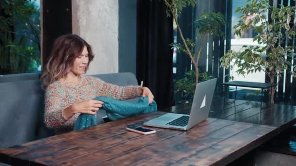 快乐的博客女孩坐在咖啡店里用笔记本电脑聊天 — 图库视频影像