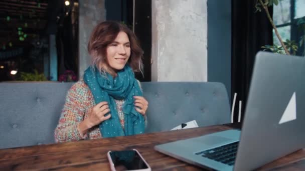 幸せなブロガーの女の子がカフェに座ってノートパソコンで話している — ストック動画