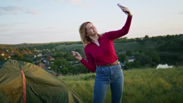 一个年轻的女人喜欢在日落时用电话在山上进行视频交流 在徒步旅行后放松一下 一个人在自然界中的休息 在山里 — 图库视频影像
