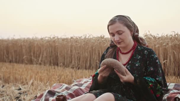 Девушка Пшеничном Поле Ломает Буханку Хлеба Нюхает Запах Хлеба — стоковое видео
