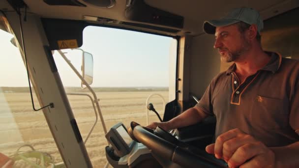 Landbouwer Exploiteert Een Oogstmachine Oogst Tarwe Het Veld Zonsondergang — Stockvideo