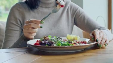 İki genç ve mutlu kadın leziz tavuk, domates ve kızarmış ekmek salatasının tadını çıkarıyorlar. Sıcak yaz mevsiminde güzel bir yerde çatalla yiyorlar.