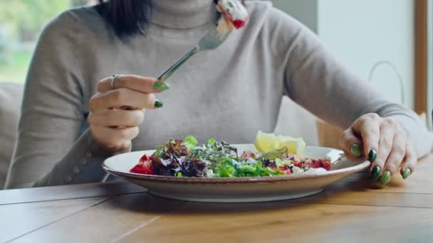 两个年轻快乐的女人享受着美味的鸡肉沙拉 西红柿和克罗顿 在炎热的夏天 用叉子在一个美丽凉爽的地方吃 — 图库视频影像