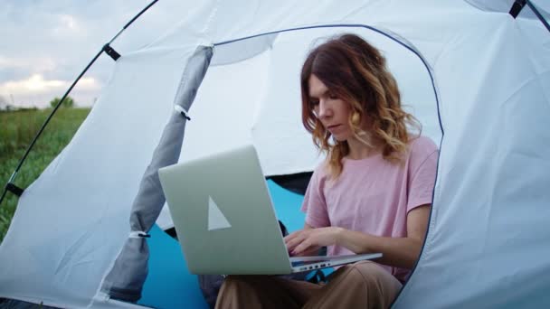 一个年轻的女人很乐意通过笔记本电脑的视频链接与人交流 在高山上工作 一个人在自然界中的休息 在山上 遥远的工作 — 图库视频影像