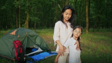 Mutlu Asyalı kadın kızıyla birlikte tatilden zevk alıyor, ormanda vakit geçiriyor. Aile için kamp yapmak. Yaz ve şehir parkı, şehrin yanında.