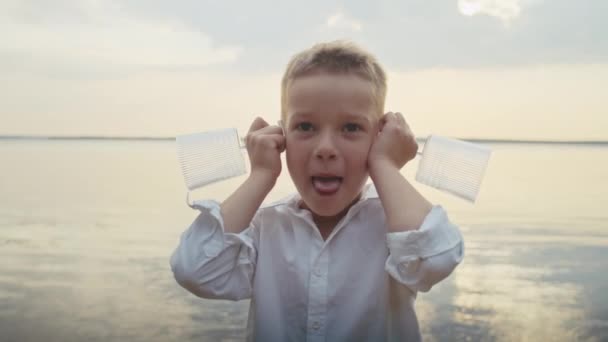 Neşeli Bir Çocuk Havuza Girer Kulaklarına Bardak Dayar Yüzünü Buruşturur — Stok video