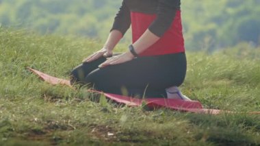 Dışarıda yoga yapan mutlu genç bir kadın. Yazın doğada nefes egzersizleri.