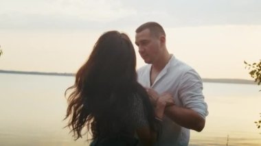 Mutlu romantik çift plajda günbatımı yürüyüşünün tadını çıkarıyor, tatil hayatı tarzı seyahat ediyor.