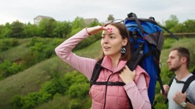 Dağlarda yaşayan mutlu çift, erkek ve kadın, tatil yeri aramak için seyahat ediyorlar. Sevinçten havalara uçarlar, güzel bir manzaranın arka planında durarak. Dağlarda tatil