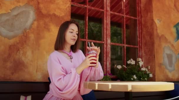 Glückliches Mädchen Rosa Kleid Trinkt Einen Cocktail Auf Der Straße — Stockvideo