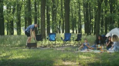 Mutlu arkadaşlar, anne, baba, oğul, kız ve arkadaşları orman bölgesinde piknik yapıyorlar. Aile yazın kamp yapıyor. Forest City Park 'ta çadırda dinleniyor.