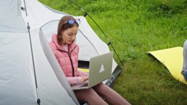Mutlu çift, dağlarda dizüstü bilgisayar ve telefonla çalışan kadın ve erkek. Dağlarda tatil. Aile kampı