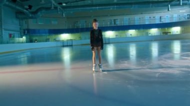 Genç bayan artistik patinajcı buz üzerinde artistik patinajla meşgul. Farklı hareketler ve dönüşler yapıyor. Yarışma başlamadan önce pistte koreografi eğitimi aldım. Teknoloji konsepti