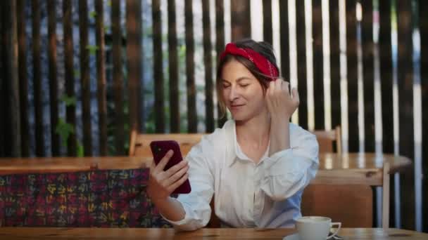 Szczęśliwa Dziewczyna Rozmawia Przez Telefon Lub Oglądanie Wideo Kawiarni Ulicznej — Wideo stockowe