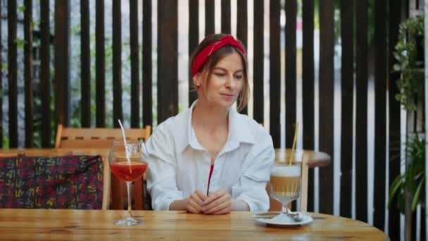 咖啡馆里快乐的女孩选择喝什么 咖啡还是鸡尾酒 夏天的生活方式和享受 — 图库视频影像