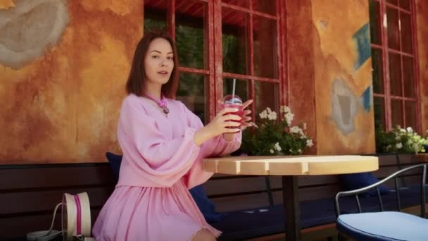Gelukkig Meisje Een Roze Jurk Drinkt Een Cocktail Straat Tegen — Stockvideo