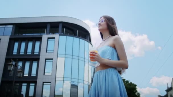 Uma Menina Feliz Vestido Azul Óculos Bebe Coquetel Rua Contra — Vídeo de Stock