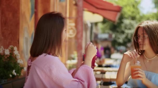 2人の若い女性の彼女はカフェでおいしいカクテルを楽しみます 場所で時間を過ごします 夏のライフスタイル — ストック動画