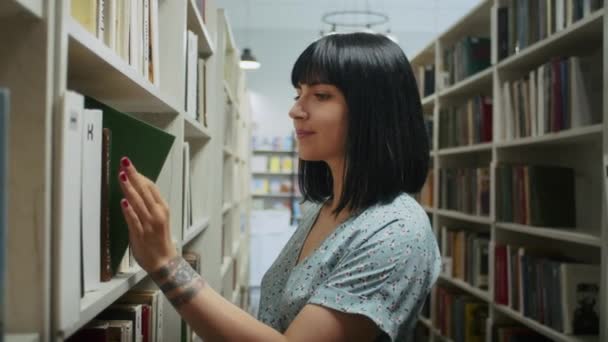 Happy Dreamy Woman Reads Book Library Chooses Books Shelf Learning — Stockvideo
