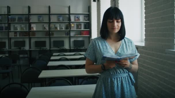 Happy Dreamy Woman Reads Book Library Chooses Books Shelf Learning — Vídeo de Stock