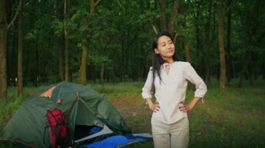 Mutlu Asyalı kadın kızıyla tatilden zevk alıyor, orman yolunda yürüyor, termostan çay içiyor. Aile için kamp yapmak. Yaz ve şehir parkı, şehrin yanında.