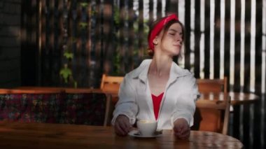 Bir kafede mutlu bir kız kahve içer, yazın eğlenir ve yaşam tarzını öğrenir.