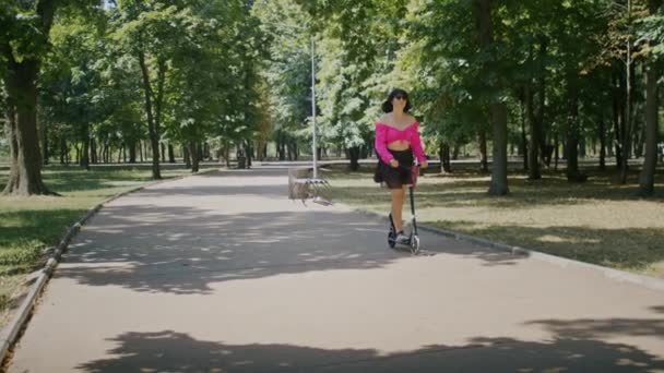 Menina Brincalhão Gosta Verão Monta Uma Scooter Pelas Ruas Parque — Vídeo de Stock