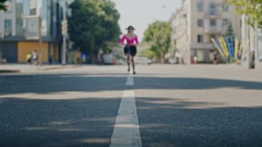 Neşeli kız yazın tadını çıkarıyor ve park ve şehir sokaklarında scooter sürüyor.
