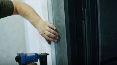 Profesyonel bir erkek usta bir daireye kapı yerleştiriyor.