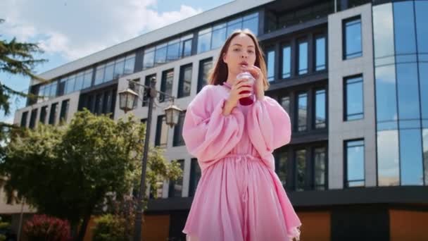 Glad Flicka Rosa Klänning Dricker Cocktail Gatan Mot Bakgrunden Byggnaden — Stockvideo