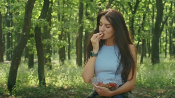 Ευτυχισμένη Γυναίκα Που Απολαμβάνει Τρώει Ώριμες Φράουλες Ενώ Στέκεται Στο — Αρχείο Βίντεο