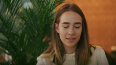 Kafede çay içip telefonda ya da görüntülü konuşma yapan neşeli bir kız. İyi eğlenceler.