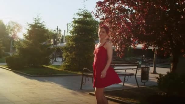 Chica Feliz Vestido Rojo Caminando Parque Disfrutando Del Sol Poniente — Vídeo de stock