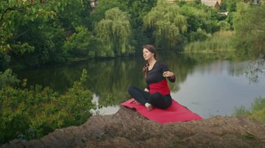 Dışarıda yoga yapan mutlu genç bir kadın. Yazın doğada nefes egzersizleri.