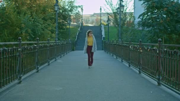 Νεαρή Ευτυχισμένη Γυναίκα Γυαλιά Περπατά Κατά Μήκος Της Γέφυρας Στο — Αρχείο Βίντεο