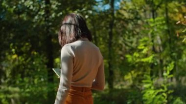 Sonbahar parkında genç bir kadın telefonda mesajlaşıyor. Sonbahar havası. gençlik ve güzellik