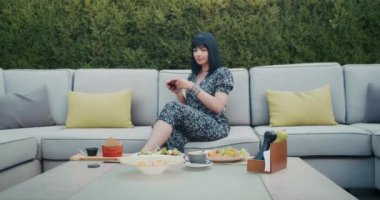 a happy woman photographs beautiful food in a restaurant, she is filled with joy