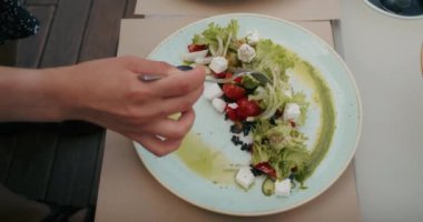 a cheerful woman enjoys food in a restaurant, she eats it with pleasure and fills her with joy