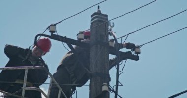 a team of male electricians perform work on the replacement of the cable.